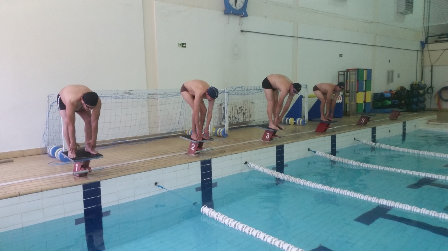 Imagem: Quatro usuários posicionados uma ao lado do outro. Cada um em uma raia diferente se preparando para entrar na piscina.